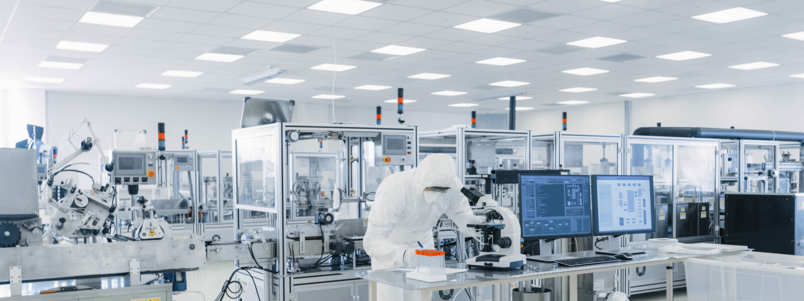 Shot of Sterile Pharmaceutical Manufacturing Laboratory where Scientists in Protective Coverall’s Do Research, Quality Control and Work on the Discovery of new Medicine.