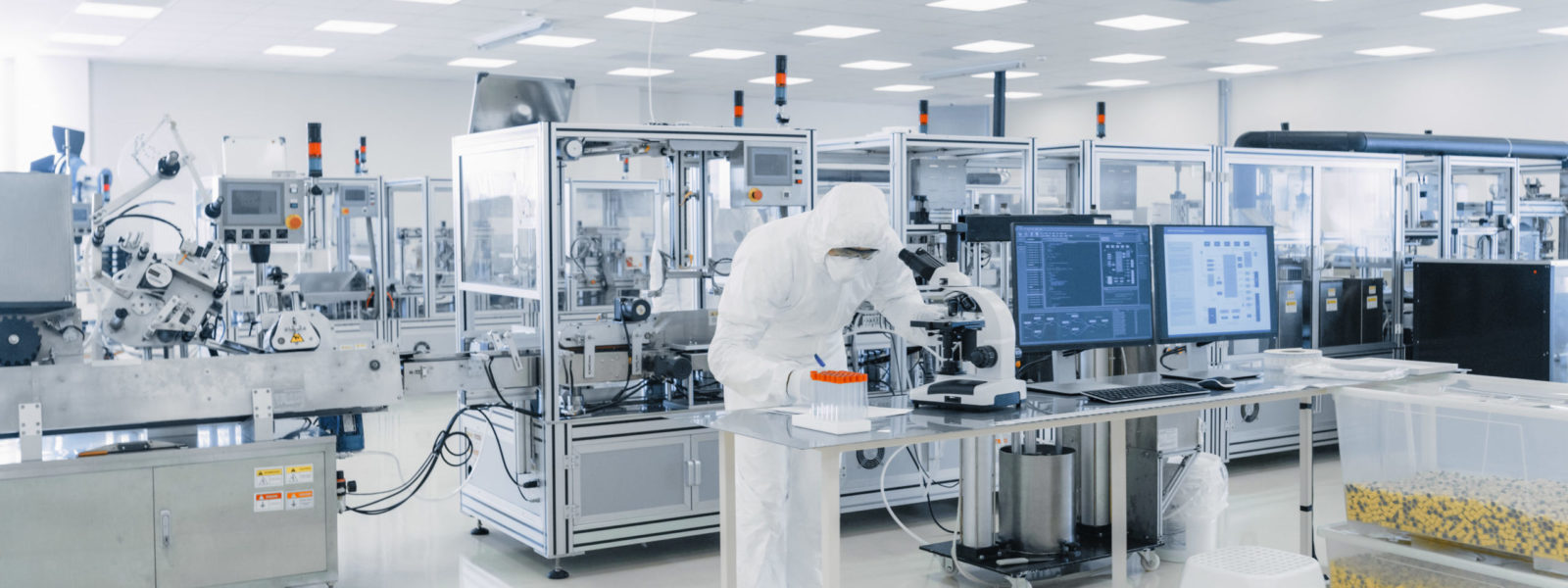 Shot of Sterile Pharmaceutical Manufacturing Laboratory where Scientists in Protective Coverall’s Do Research, Quality Control and Work on the Discovery of new Medicine.