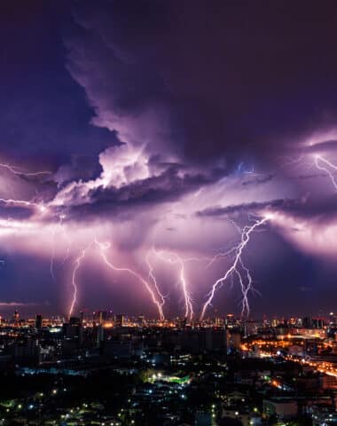 Lightning storm over city in purple light