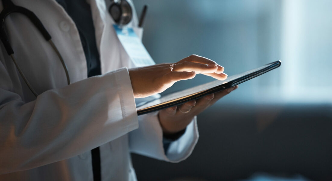 Telehealth, digital tablet and doctor hands for hospital innovation, software management and results update in dark workplace. Healthcare, cardiology and telecom medical professional with technology