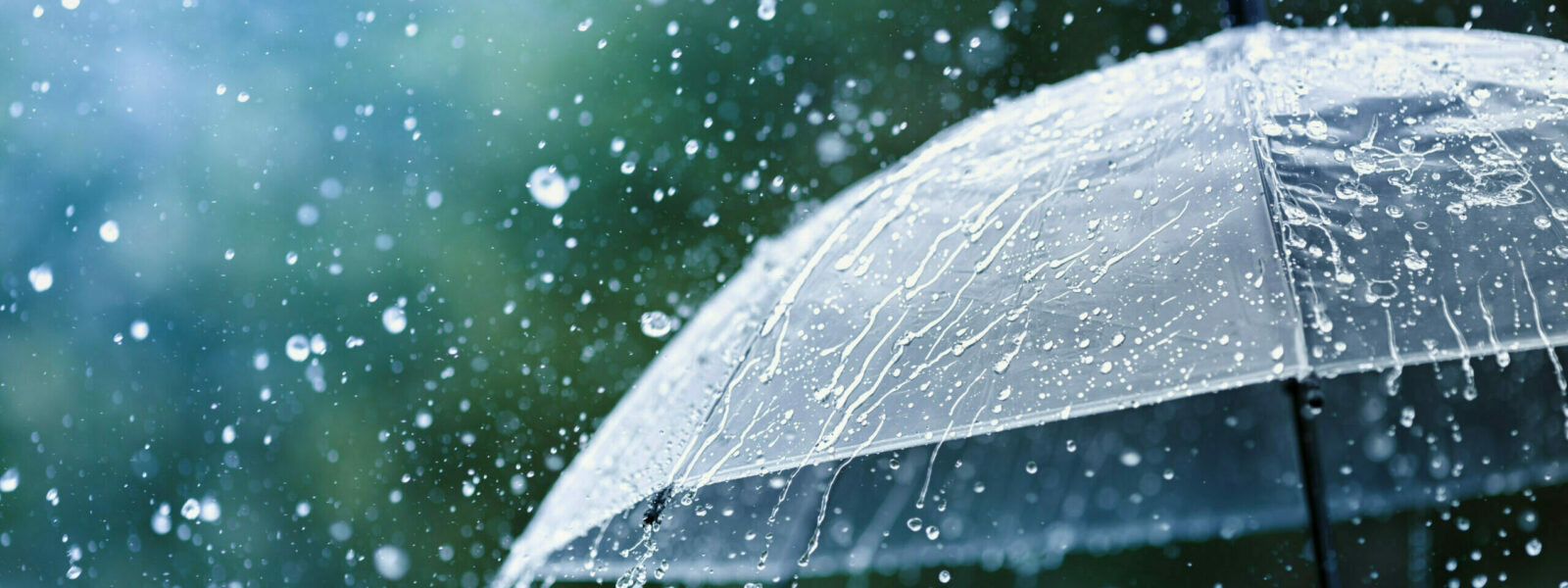 Transparent umbrella under rain against water drops splash backg