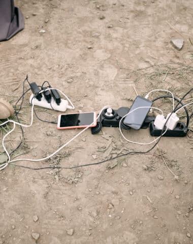 Hand of young man holding smartphone on charge
