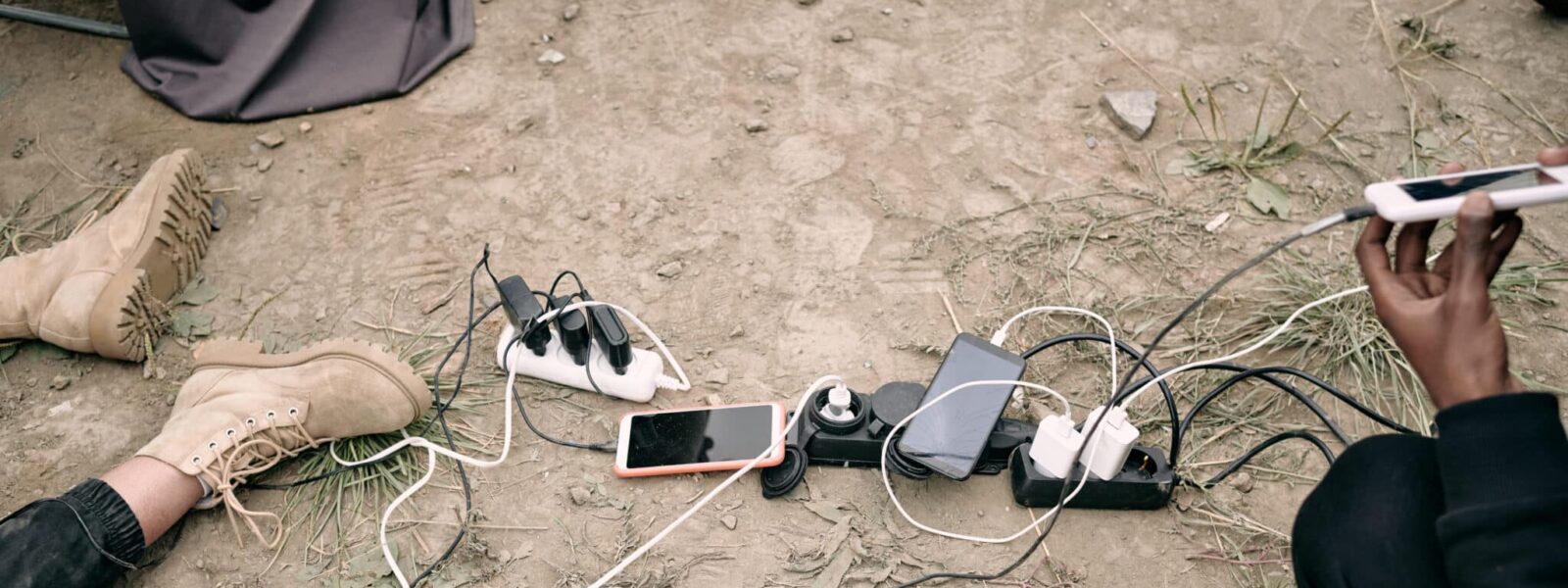 Hand of young man holding smartphone on charge
