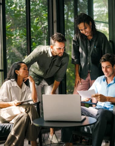 Group of young multi-ethnic startup business team collaborating on project in modern office