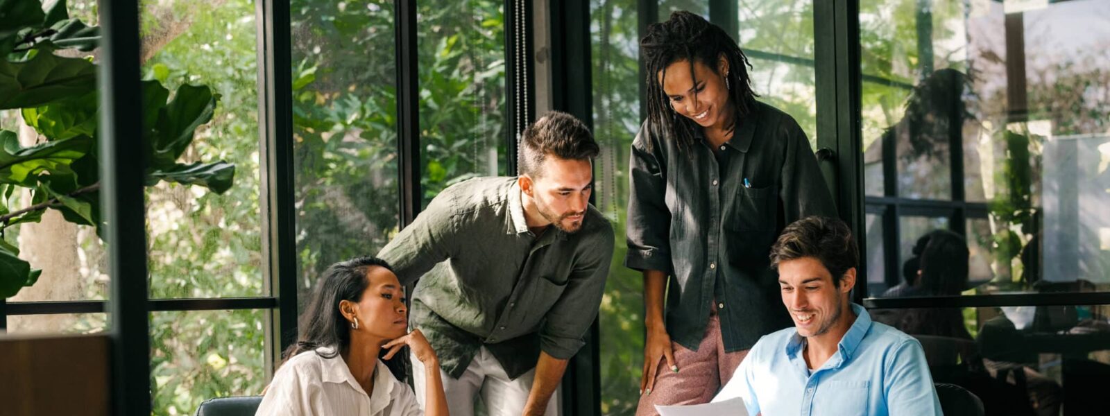 Group of young multi-ethnic startup business team collaborating on project in modern office