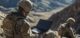 Soldier Using Laptop in Mountainous Terrain