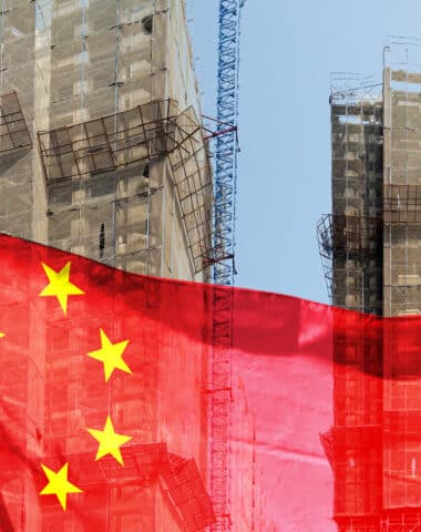 Double exposure creative hologram of unfinished supertall building and Chinese flag